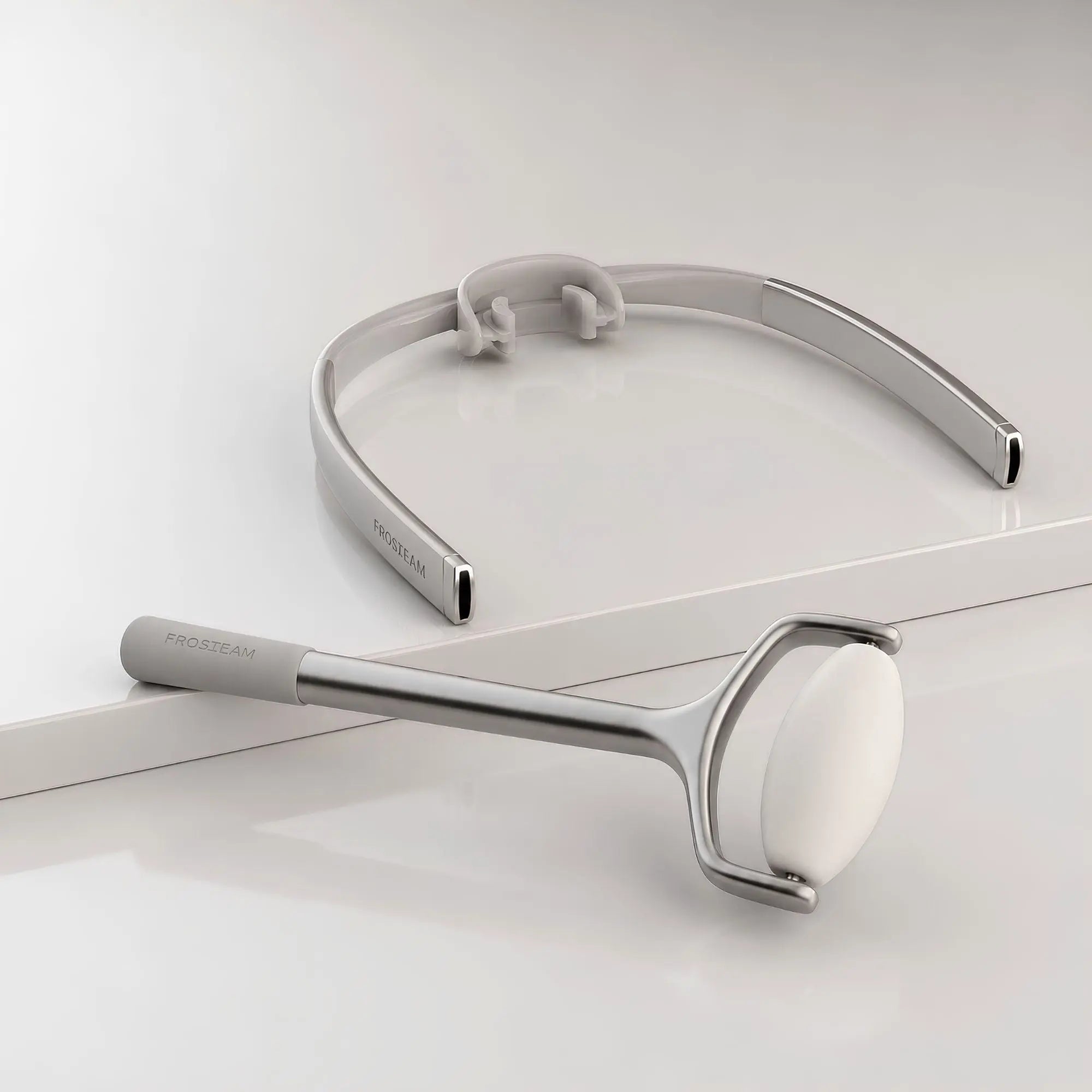 Frosteam Face Roller and Dive Breather luxury facial skincare tools on a minimalist light gray studio background.