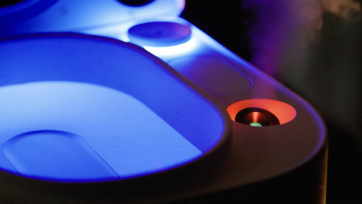 Close-up of the Frosteam Harmony 3-in-1 facial spa: blue-lit facial cold plunge basin, aromatherapy diffuser outlet glowing orange and nano-ionic steam rising