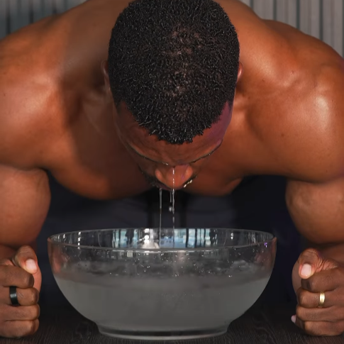 Ashton Hall using ice water bowl for cold therapy skincare ritual, refreshing and tightening the skin.
