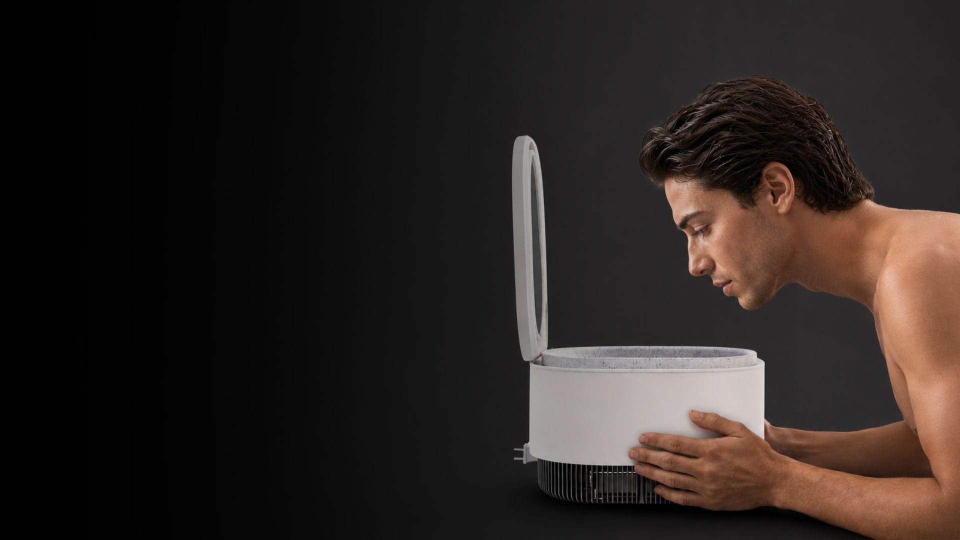 Man leaning toward the Frosteam Harmony cold-therapy basin, device open